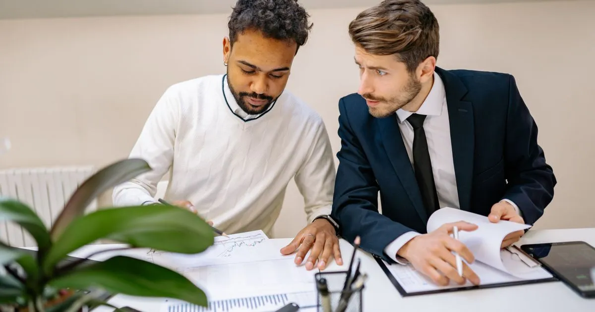 Two people comparing debt relief solutions on charts at a desk in Canada
